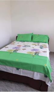 een bed met een groen dekbed en groene kussens bij Refuge celeste : Votre Havre Numerique in Lomé