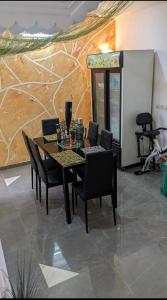 een eetkamer met een tafel en stoelen en een muur bij Refuge celeste : Votre Havre Numerique in Lomé