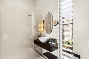 a bathroom with a sink and a mirror at The Longhouse - Suite 1 in Pokolbin