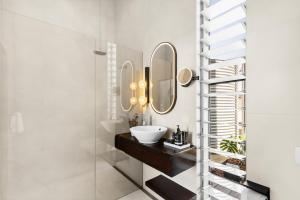 un baño con lavabo y espejo en The Longhouse - Suite 1, en Pokolbin