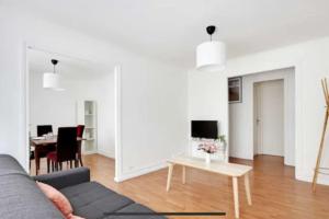 sala de estar con sofá y mesa en Superbe appartement lumineux et calme en Saint-Ouen