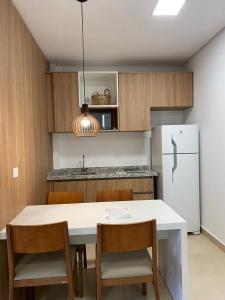 a kitchen with a white table and a refrigerator at Apartamento completo resort in Represa Capivari