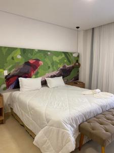 Represa Capivari的住宿－Apartamento completo resort，卧室配有一张大床,墙上挂有绘画作品