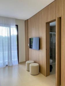 a living room with a flat screen tv on a wall at Apartamento completo resort in Represa Capivari