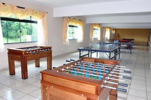 a room with two ping pong tables and two tables at Apartamento completo resort in Represa Capivari