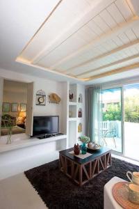 a living room with a coffee table and a television at The Chelona in Khao Tao