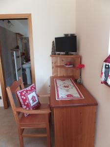 Challand Saint AnselmeにあるMaison Gaudenzioのデスク、椅子、テレビが備わる客室です。