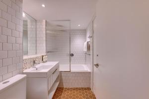 a bathroom with a tub and a sink and a shower at Adina Apartment Hotel Chippendale in Sydney