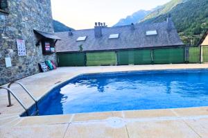 una gran piscina frente a una casa en El Hechizo de Biescas en Biescas