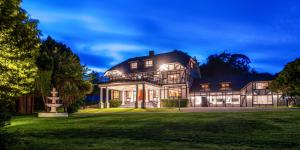 a large house with a lawn in front of it at Hana Lodge in Rotorua