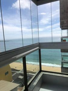 uma vista para o oceano a partir de um edifício com uma praia em Flat reformado 1306 na Praia da Costa 1950 Edifício Ocean Flat em Vila Velha