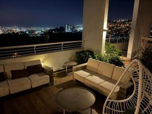 a living room with a couch and tables on a balcony at Departamento en Viña del Mar in Viña del Mar