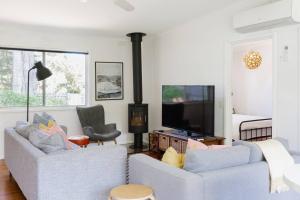 uma sala de estar com dois sofás e uma lareira em Shoreline Sanctuary - A Retro Family Beach Shack em Somers