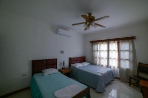 una camera con 2 letti e un ventilatore a soffitto di HOSTAL RIVAS INNS a Rivas
