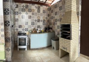 a kitchen with a stove and a sink in it at Casa da Pri in Rio das Ostras