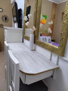 a dressing table with a mirror and a bench at Jazmines Apart in Martínez