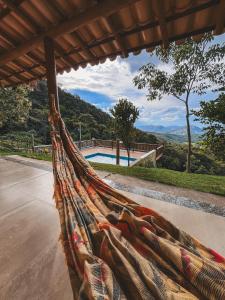 a hammock with a view of a pool at Chalés do alegre in Capitólio
