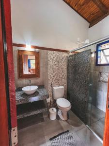 W łazience znajduje się toaleta, umywalka i prysznic. w obiekcie Chalés do alegre w mieście Capitólio