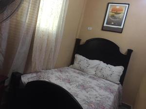 a small bedroom with a bed with a floral bedspread at La hermosa hotel in Santa Cruz de Barahona