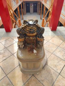a statue sitting on a tile floor in a building at Hotel Chinesca in Mexicali