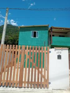 a wooden fence in front of a house at Meu cantinho in Ubatuba