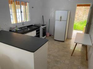 a kitchen with a white refrigerator and a stove at Excelente casa com piscina próximo SP in Nazaré Paulista