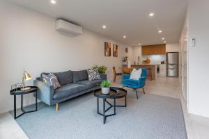 uma sala de estar com um sofá e duas mesas em Urban Nest - Entire Townhouse and Free Parking em Christchurch