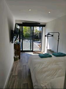 um quarto com uma cama e uma porta de vidro deslizante em The Cute Cabin em Santon