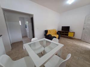 sala de estar con mesa de cristal y sillas blancas en Excelente casa com piscina próximo SP, en Nazaré Paulista