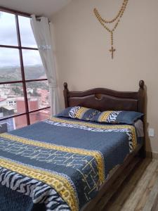 a bed in a room with a window at Hostal S.Pacha in Sucre