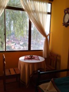 a table in a room with a large window at Hostal S.Pacha in Sucre