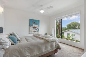 a bedroom with a bed and a large window at Waiheke Island Resort Conference & Accomodation Centre in Ostend