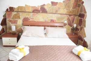 sypialnia z dużym łóżkiem z ręcznikami w obiekcie La Bouganville w mieście Vitorchiano