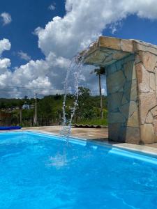 een zwembad met een fontein bij Excelente casa com piscina próximo SP in Nazaré Paulista