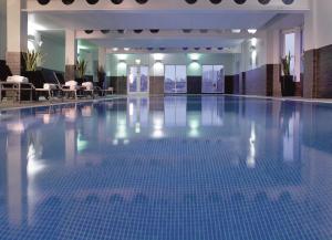 a large swimming pool with blue tiles in a building at Macdonald Old England Hotel & Spa in Bowness-on-Windermere