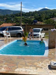 een groep kinderen die spelen in een zwembad bij Excelente casa com piscina próximo SP in Nazaré Paulista