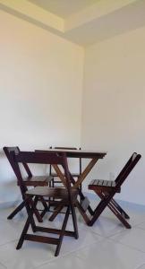uma mesa de madeira e uma cadeira ao lado de uma parede em APTO - perto da praia - Piscina - Cabedelo João Pessoa em Cabedelo