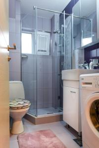 y baño con ducha, aseo y lavamanos. en Skopje Luxury Apartments en Skopje