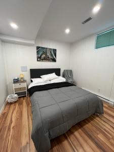1 dormitorio con 1 cama grande y suelo de madera en Bertha's charming urban retreat, en Laval