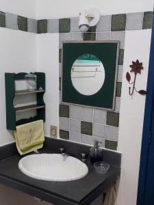 een badkamer met een wastafel en een foto aan de muur bij Recanto das tartarugas in Mangaratiba