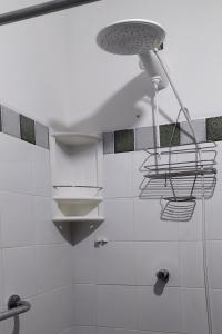a white bathroom with a shower and a light at Recanto das tartarugas in Mangaratiba