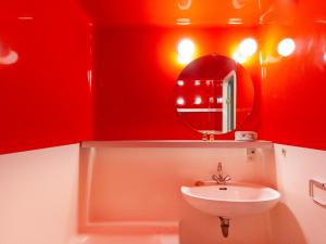 a red bathroom with a sink and a mirror at Studio Les Arcs 2000, 1 pièce, 5 personnes - FR-1-346-372 in Arc 2000