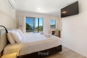 a bedroom with a large bed with a large window at Waiheke Island Resort Conference & Accomodation Centre in Ostend