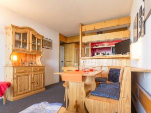 a kitchen with wooden cabinets and a desk with a chair at Appartement Les Arcs 1800, 2 pièces, 5 personnes - FR-1-346-427 in Arc 1800