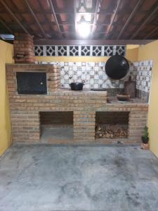 a brick fireplace in a room with a pan at Chalé Santa Rita in Bonito