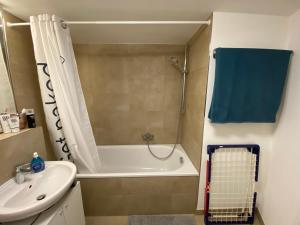 a bathroom with a tub shower and a sink at Shared apartment in former hotel, near train station, fully equipped kitchen with washer-dryer in Hürth