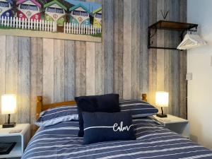 a bedroom with a bed with blue and white stripes at Bella Vista in Paignton