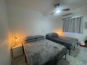1 dormitorio con 2 camas y ventilador de techo en El Balcón de Luly, en Culebra
