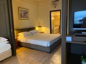 a bedroom with a bed and a flat screen tv at Makam Service Suites Times Square in Kuala Lumpur