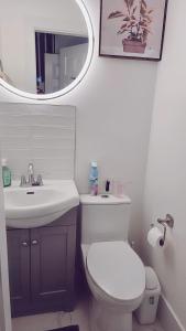y baño con aseo, lavabo y espejo. en Private King Room - Shared Washroom - 5 min to Surrey Fleetwood en Surrey